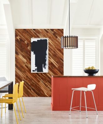 A bright, open modern kitchen with an orange island, wood accent wall and bright white vaulted ceiling.