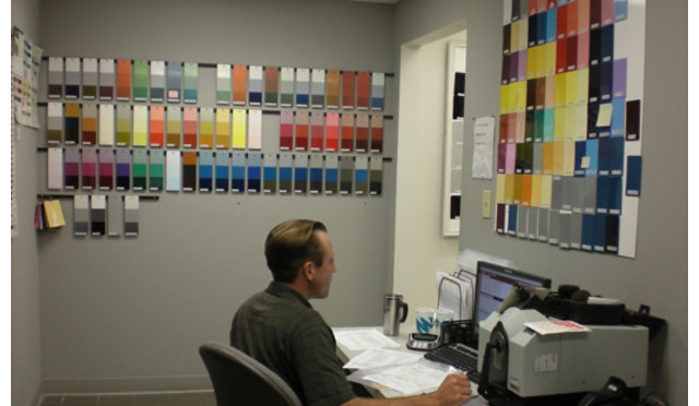 Technician surrounded by color panels on wall