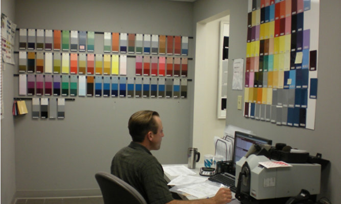 Technician surrounded by color panels on wall