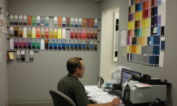 Technician surrounded by color panels on wall