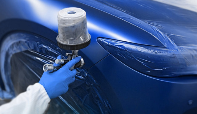 Spraygun application of blue automotive paint.