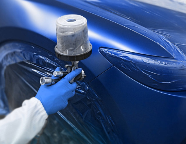 Spraygun application of blue automotive paint.