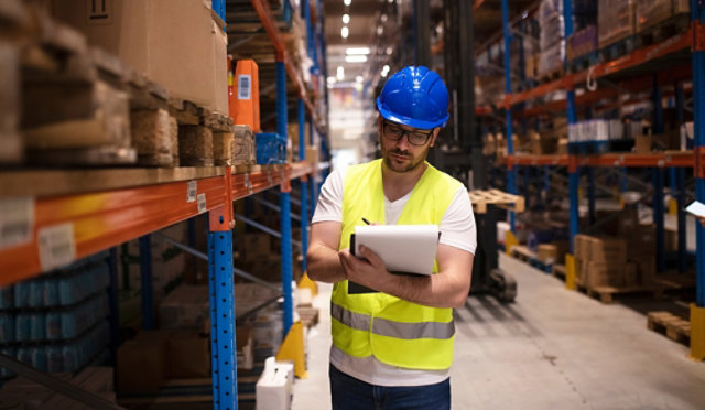 A warehouse employee checking shelf life information on a device