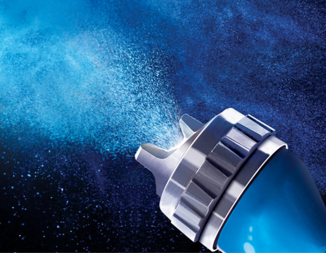 Close up of a spray gun nozzel, sparying paint.