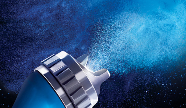 Close up of a spray gun nozzel, sparying paint.