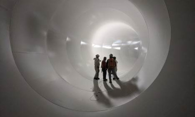 crew members inspecting water tank interior after coating was applied