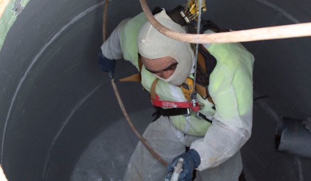 man in sewer applying coatings