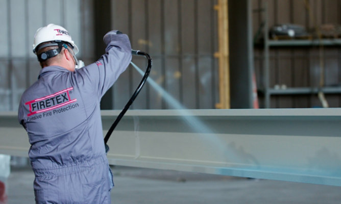 person spraying fire protection coating onto steel beam