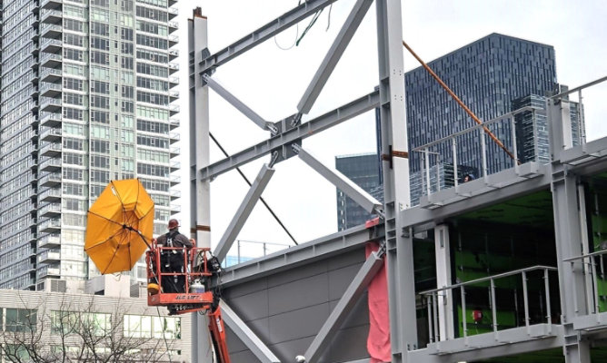 Steel workers bolting intumescent coated steel structural beams together