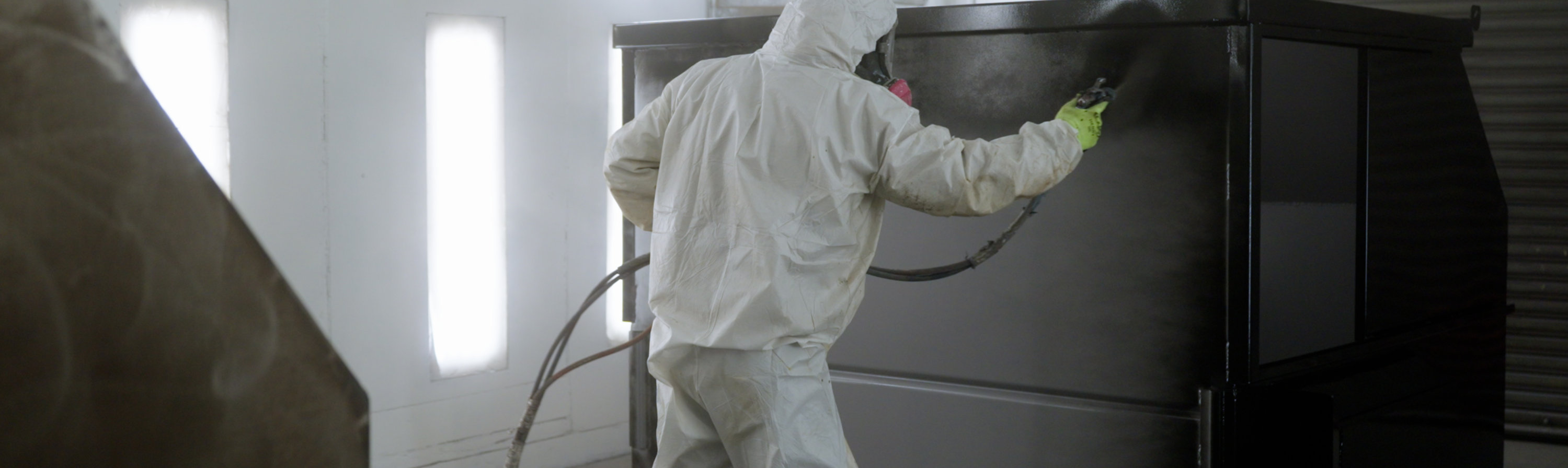 spray application of coating to front of dumpster