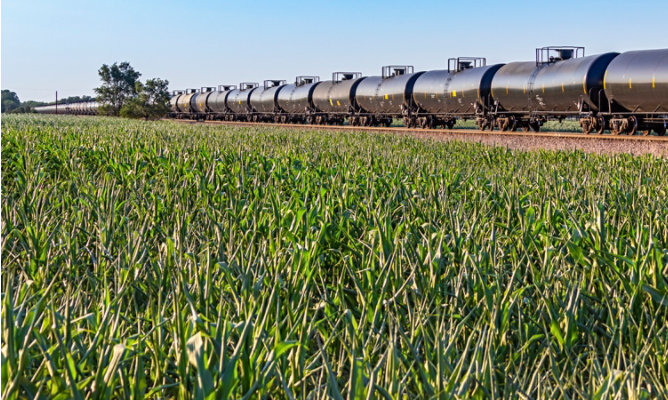 rail cars next to grain field