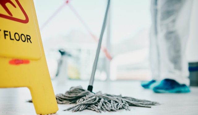 mop on floor with caution sign