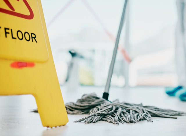 mop on floor with caution sign