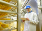 factory worker taking note of food prep