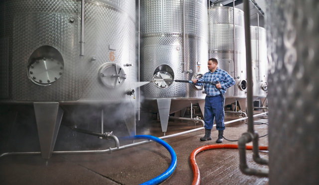 person cleaning in a brewery