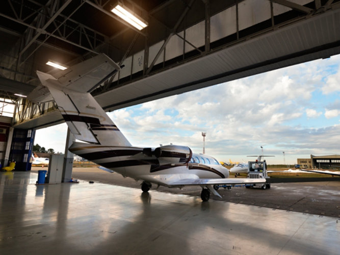 A plane leaving an aviation facility.