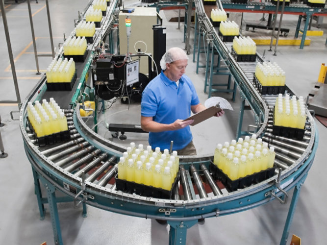 Person standing on assembly line at bottling plant