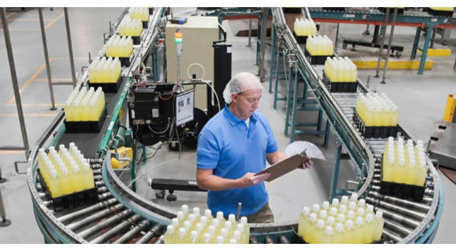 Person standing on assembly line at bottling plant