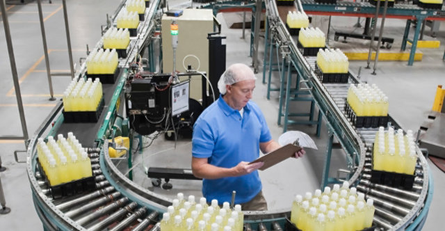 Person standing on assembly line at bottling plant