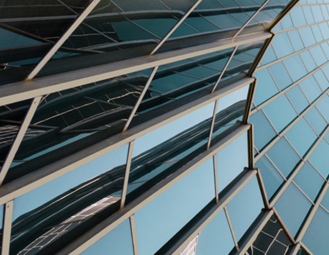 View from below of a monumental building featuring blue/black windows and extrusion coated with COTY 2026 Universal Khaki.