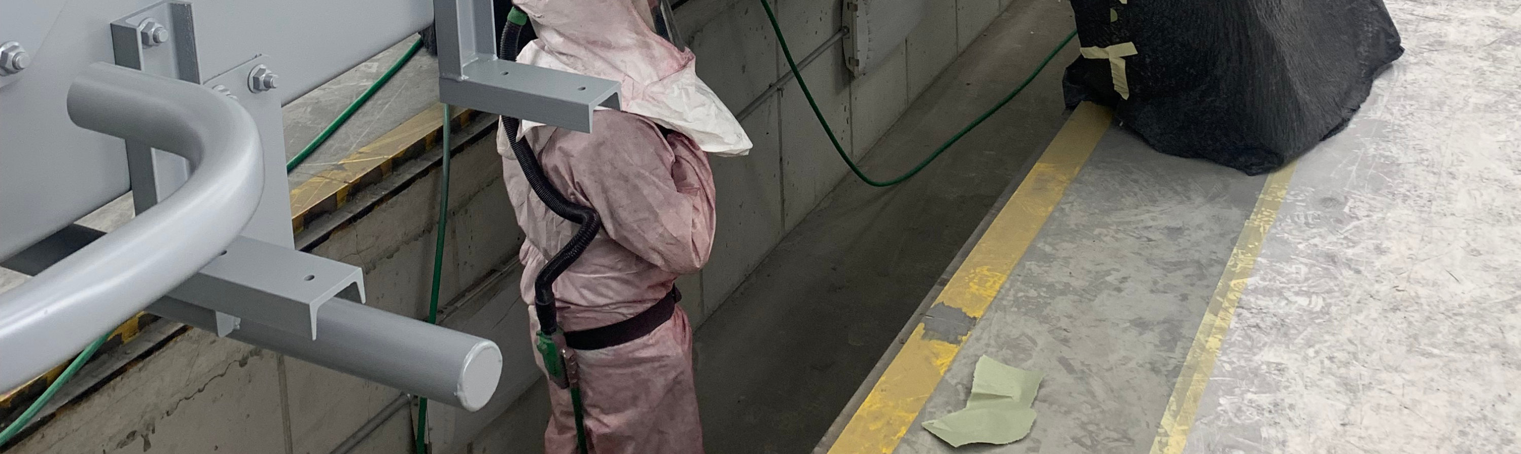 Concrete mixer truck masked with protective paper and plastic after gray coating application inside HMC’s in-house paint booth.