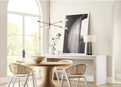 Dining room painted Sherwin-Williams Sunbleached SW9585 with a large white shelf alongside a white and light brown table set.