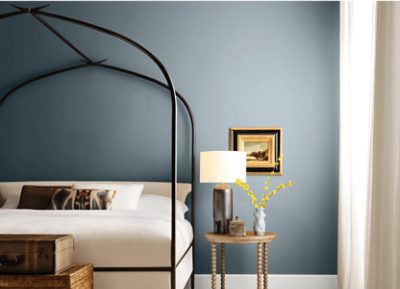 Bedroom painted Sherwin-Williams Rain Cloud SW9639 with a white bed and black canopy bed frame.