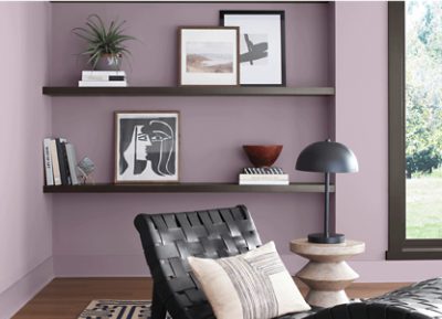 Living room painted Sherwin-Williams Mauve Finery SW6282 with a black wooden two tier bookshelf.