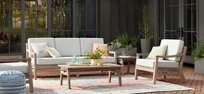 Set against a backdrop of Urbane Bronze SW 7048 (245-C7), light wood furnishings and cozy textiles create an inviting al fresco escape. Photo courtesy of Rejuvenation.