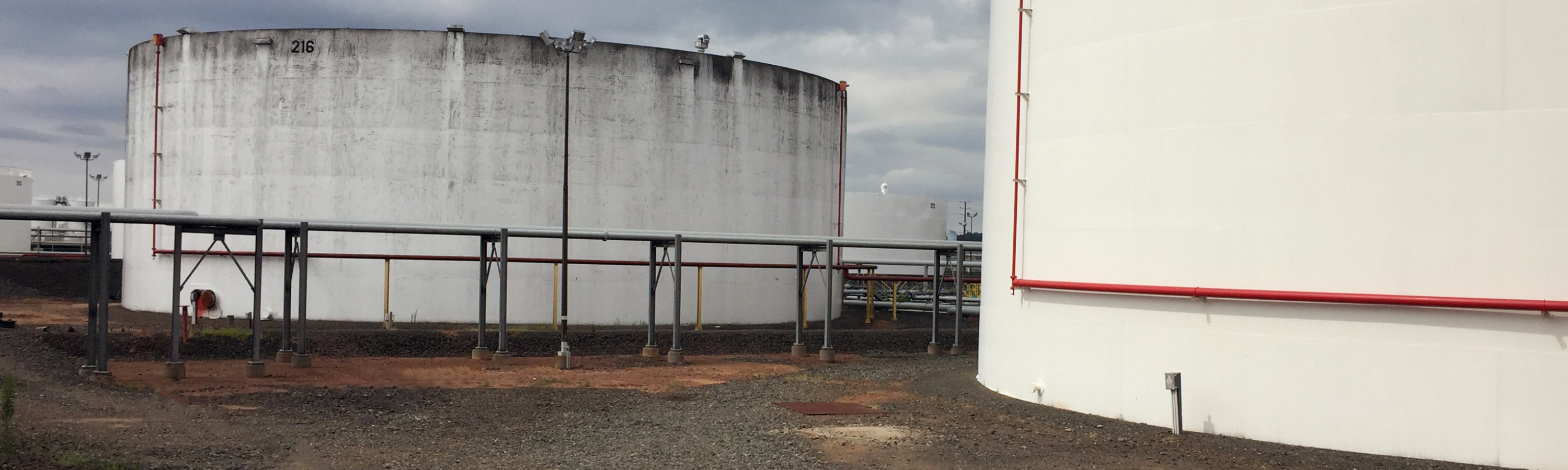 An image of two tanks. The tank in the foreground is bright, white and clean. The tank in the background is darker and mildew covered. 