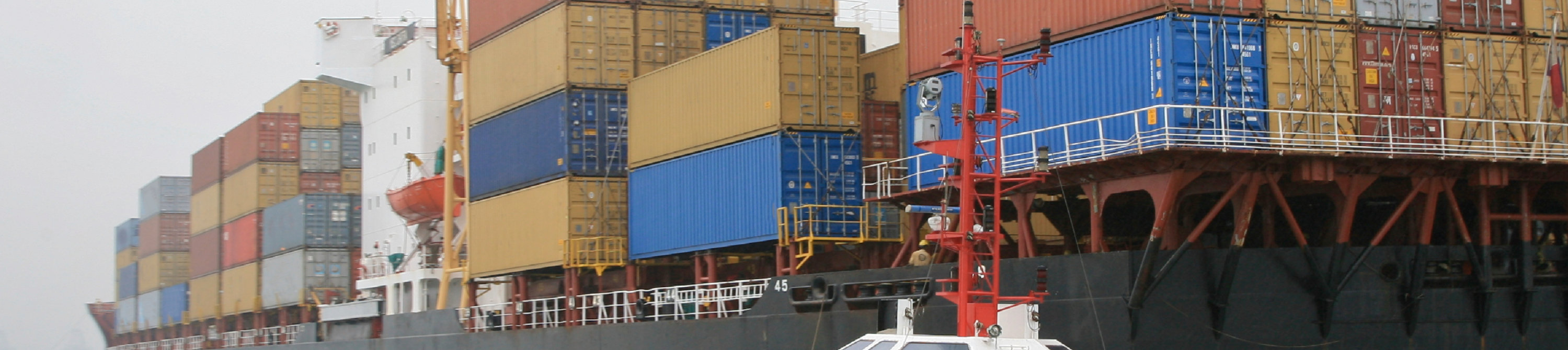 Cargo ship with smaller boat at sea