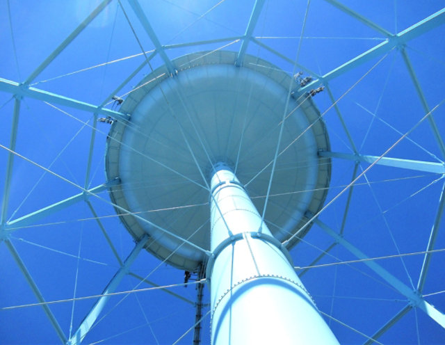 Exterior upward view of a blue water tower 