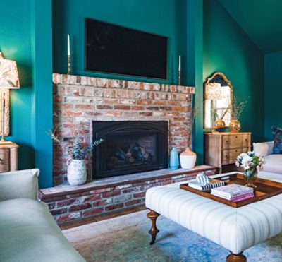living room with teal walls, a fireplace, neutral furniture.
