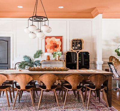 dining room with peach colored ceiling, large wooden table and chairs, white walls.