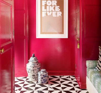 Bright pink walls with gold hardware on the doors.