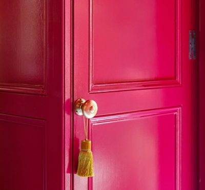 Bright pink walls with gold hardware on the doors.