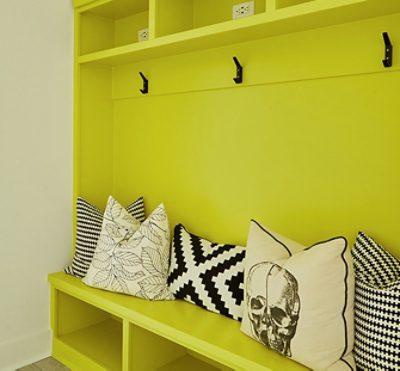 bright yellow hallway storage area decorated with black and white pillows.