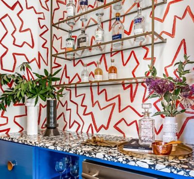 blue cabinets, black and white countertop, red and white designed walls for a wet bar.