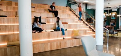 stadium type wooden seating with lighting, people interacting.