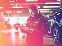 Two auto technican's discussing whilst standing with a digital tablet.