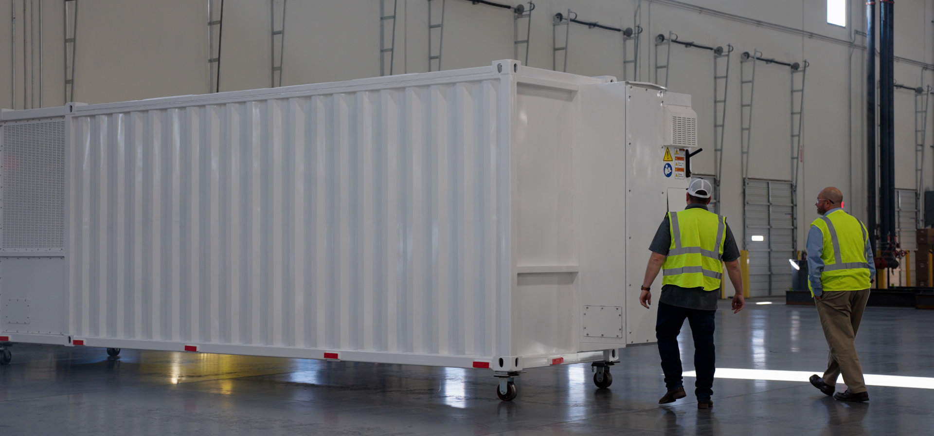 people in safety vests standing by shipping container