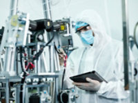 Person in full clean room attire with mask in side clean room with equipment