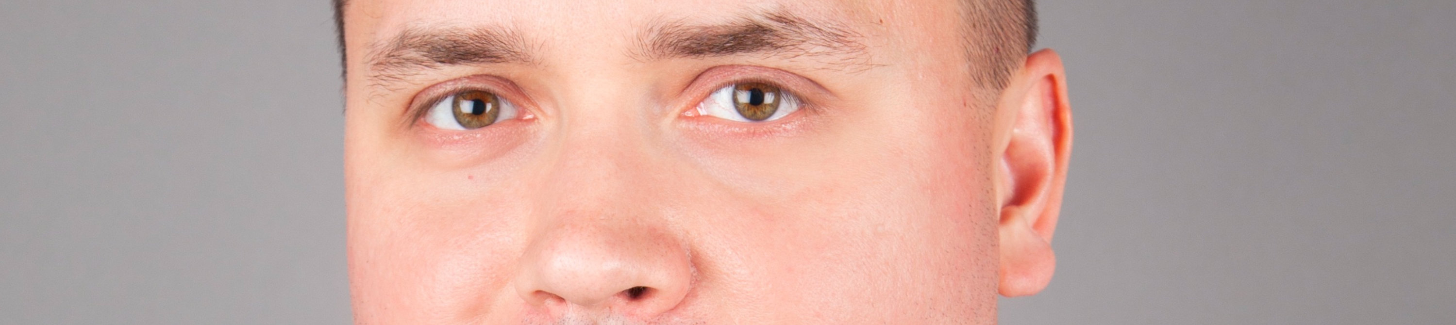 Mariusz Pietrzak headshot against a gray background.