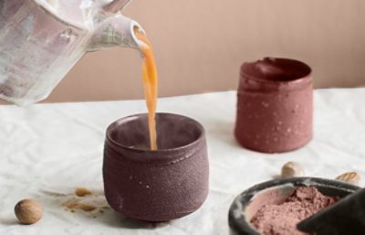 warm blush hued pottery being poured a warm drink.