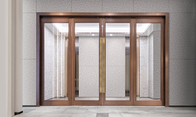 Retouched application image of interior building entry doors featuring Sherwin-Williams Emulate Stone Terrazo pattern panels in the Pebble Gray colorway 