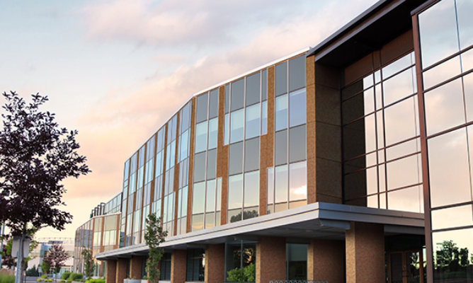 Retouched application image of a building exterior featuring Sherwin-Williams Emulate Metal Weathered pattern panels in the Patina Copper colorway 