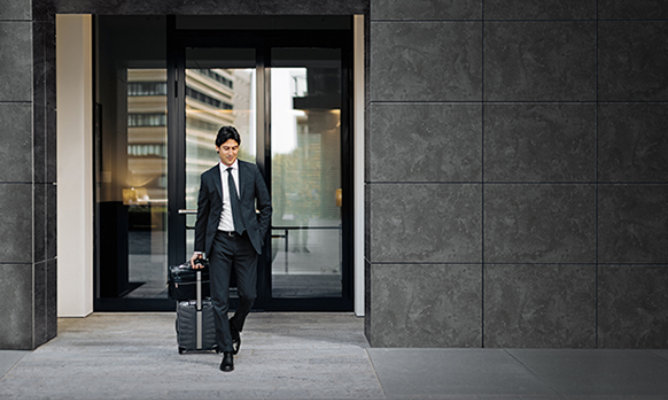 Retouched application image of a man exiting an office building featuring Sherwin-Williams Emulate Metal Burnished pattern panels in the Slate colorway 