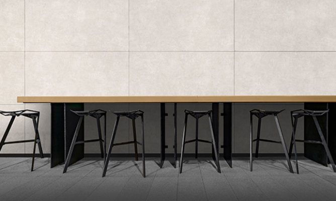 Retouched application image of an outdoor bar seating area featuring Sherwin-Williams Emulate Stone Concrete pattern panels in the Pumice colorway 