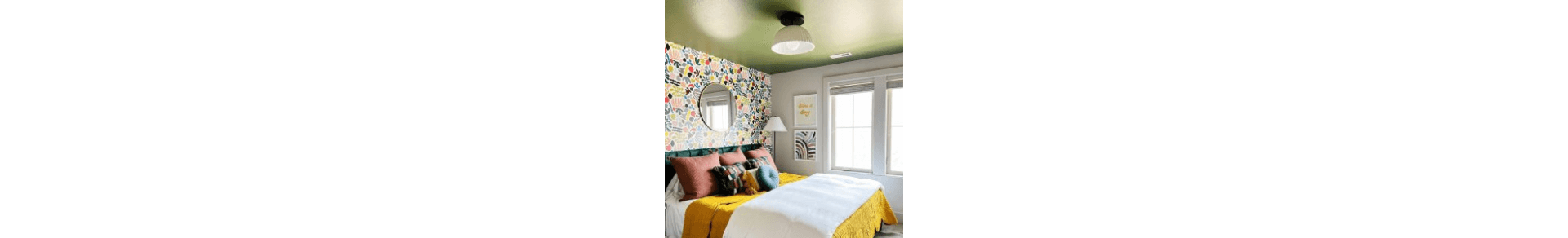 A retro style bedroom with a yellow-green painted ceiling and walls with wallpaper and white paint.