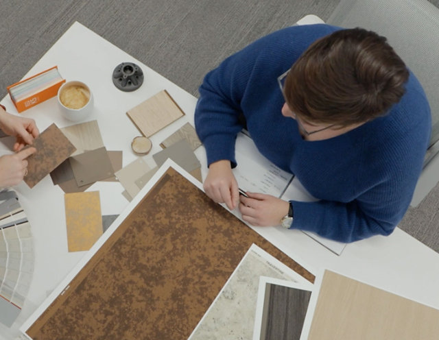 Birds eye photo of Sherwin-Williams design professionals reviewing different color swatch samples and patterns